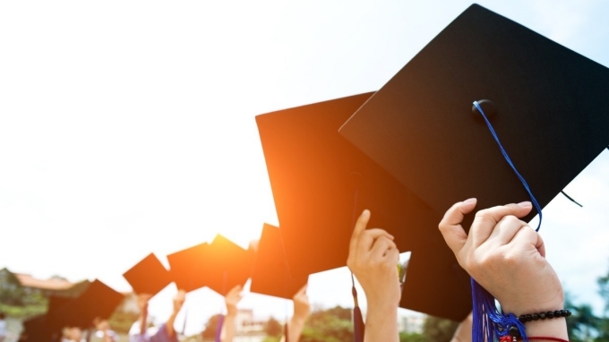 photo of students holding up their graduation caps